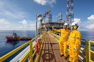 ExxonMobil workers in yellow suits offshore Malaysia