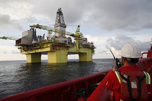 workers in front of an oil platform