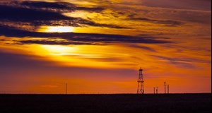 oil production rig at sunset