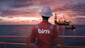 horizontal BiSN sunset image - crewmember in foreground - rig in distance