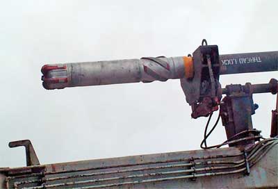 Fig. 2. The pipe-handling arm is shown picking up the operation drill tool with integral centralizer.